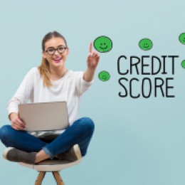 Excellent credit score theme with young woman using her laptop