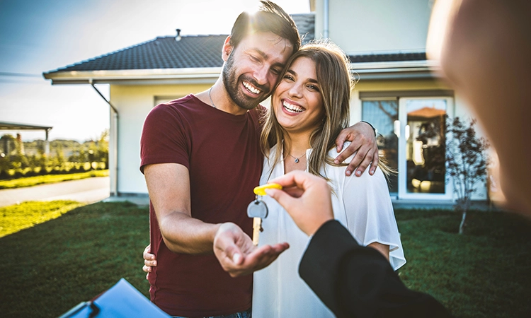 smiling couple with keys to new home